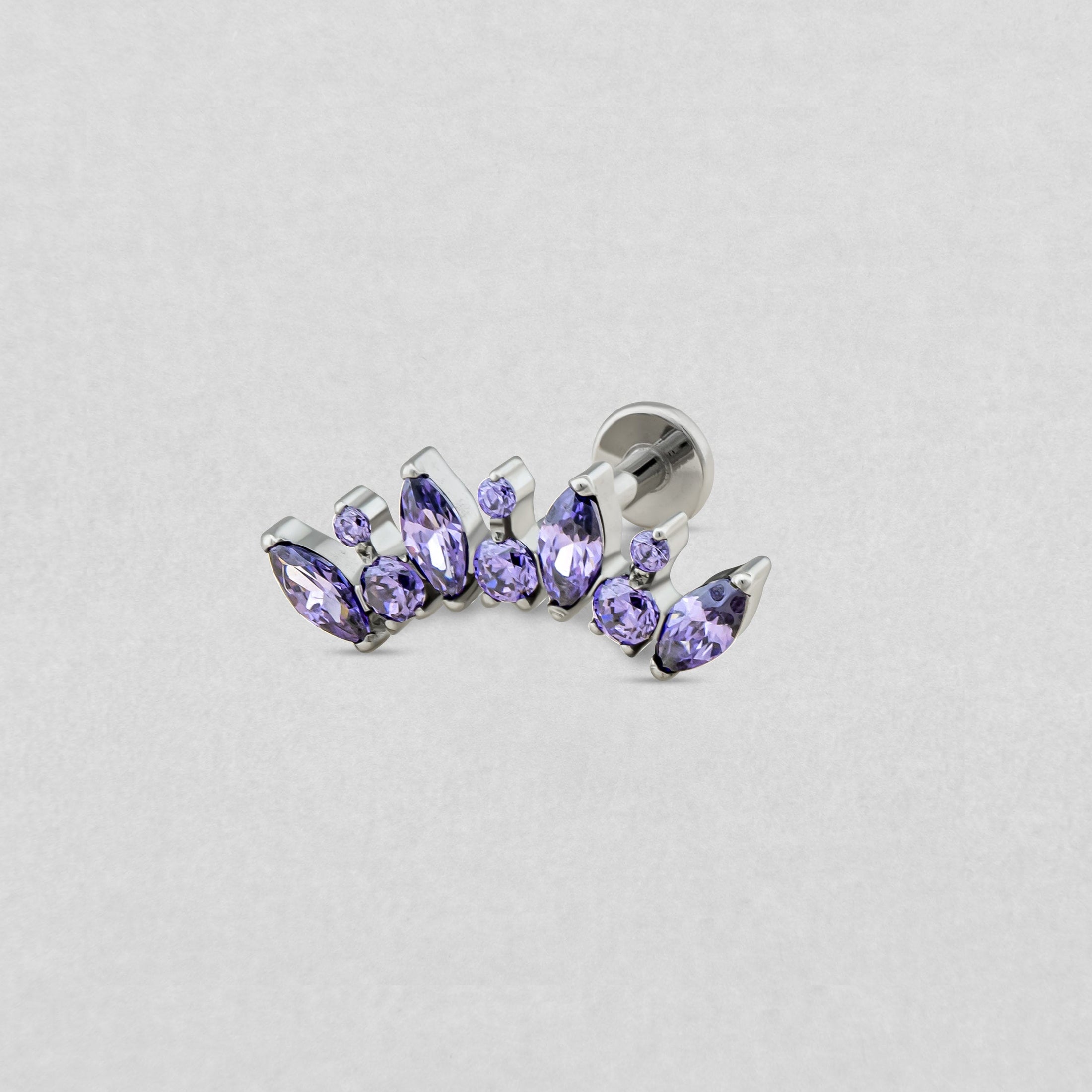 El modelo «Apolo amatista» de Titanio-Noble Art es un pendiente de plata con piedras de color lavanda en forma de pera y redondas, dispuestas en una suave curva, que se presenta en color gris claro: todo un homenaje al diseño moderno de joyería.